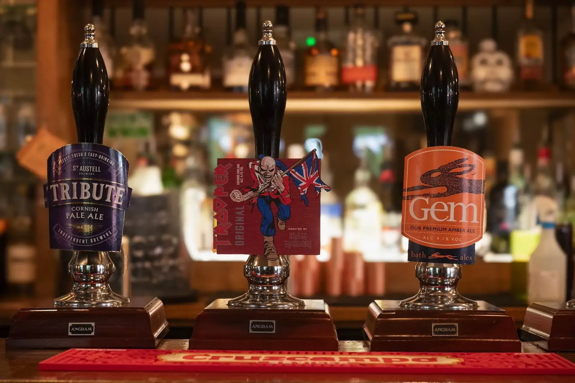 Three hand pumps on the bar with the warm back bar behind